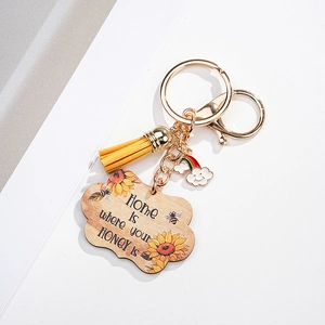 Close-up of sunflower bee wood charm with yellow tassel and golden metal lobster clasp
