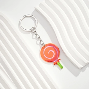 Detailed close-up of a vibrant orange spiral lollipop keychain with acrylic charm