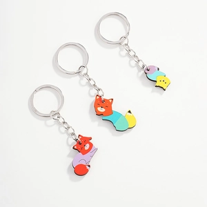 Detailed view of three colorful cartoon fox acrylic keychains with metal rings