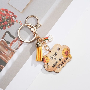 Detail of wooden sunflower keychain with yellow tassel and Home is where your HONEY is slogan