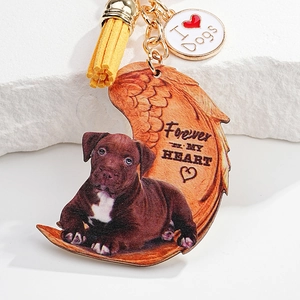 Detail of dog memorial keychain with wooden puppy charm and yellow suede tassel