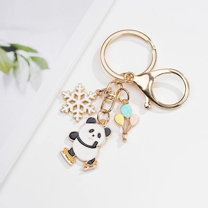 Detail of cartoon skating panda keychain with snowflake and balloons on gold zinc alloy