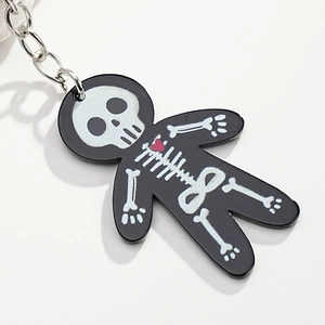 Close-up of a black acrylic skeleton keychain with a red heart and metal ring detail