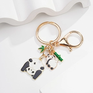 Close-up of cute panda metal keychain with green bamboo charms and gold lobster clasp