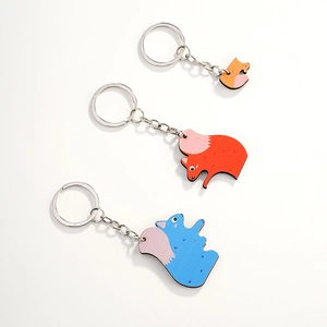 Three colorful wooden squirrel keychains in orange, red, and blue with metal rings