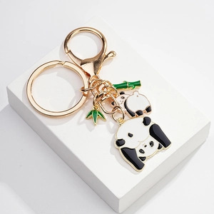 Detail of cute panda enamel keychain with green bamboo charms and gold-plated metal finish