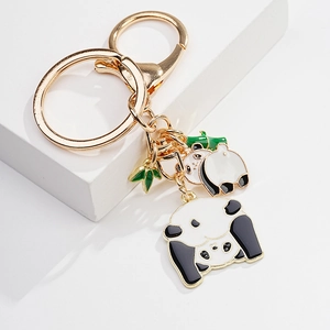 Detail of cute panda enamel keychains with golden hooks and green bamboo leaf charms