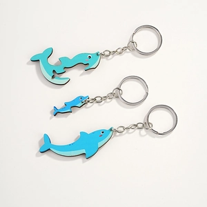 Dettaglio dei portachiavi in legno a forma di delfino e balena con anelli in metallo