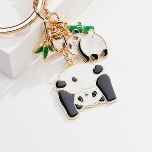 Detail shot of cute panda enamel keychain with green bamboo leaves on gold metal rings