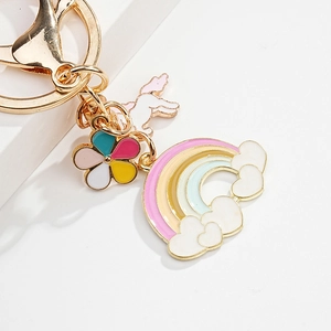 Detail of colorful rainbow, cloud and floral pendants on a gold plated metal keychain