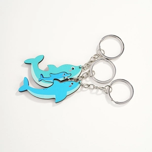 Tre simpatici portachiavi a forma di delfino in legno blu in varie dimensioni