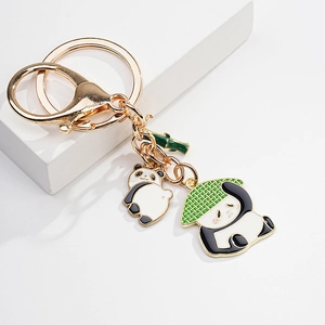 Close-up of enamel panda keychain with gold plating and green bamboo detail charms