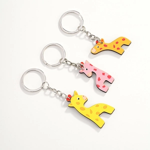 Detailed close-up of cute cartoon giraffe wooden keychains in yellow, orange and pink