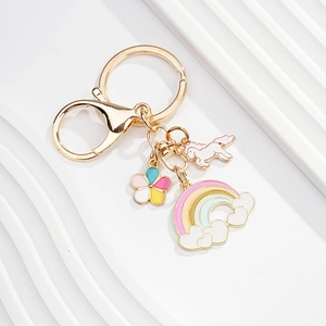 Detailed view of rainbow and unicorn charms on a gold-plated keychain with lobster clasp
