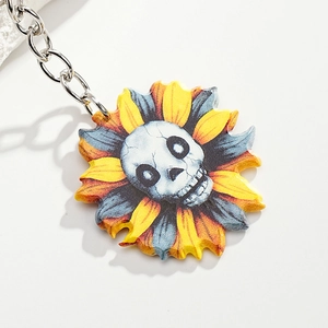 Macro shot of a gothic sunflower keychain with a detailed white skull core and yellow petals