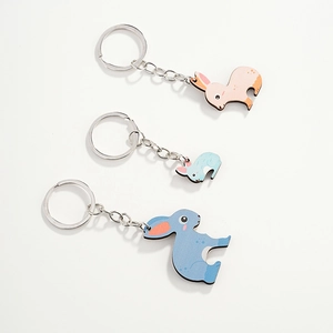 Gros plan de trois porte-clés lapin en bois colorés en rose, bleu ciel et bleu marine foncé