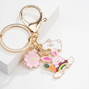 Macro shot of cute enamel bunny keychain with cherry blossom and rainbow charm details