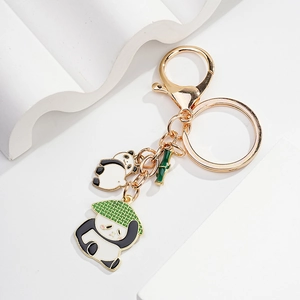 Detail of cartoon panda keychain with bamboo charm and gold lobster clasp finish