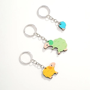 Detailed view of colorful wooden sheep keychains with textured wool finish and metal rings