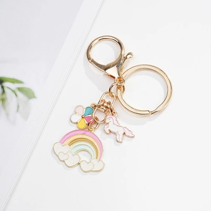 Detailed view of colorful rainbow and unicorn enamel pendants on golden keychain