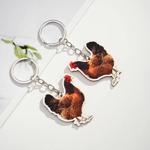 Realistic brown hen wooden pendants with silver metal keychains on a white background