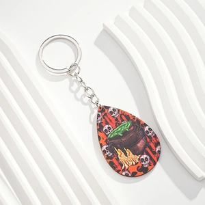Detail of teardrop Halloween keychain with witch cauldron and skull illustration