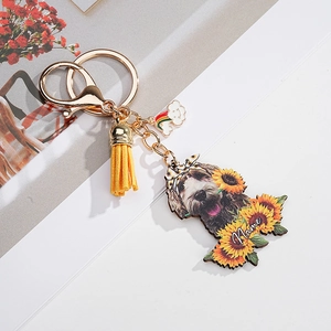 Custom dog keychain detail with yellow tassel, rainbow charm, and sunflower name design