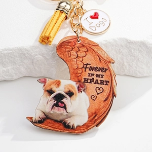 Close-up of bulldog acrylic keychain with angel wings and yellow tassel decoration