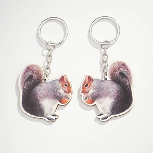 Set of two realistic squirrel wooden keychains with silver metal rings on white background