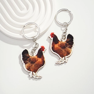 Detail view of two wooden rooster keychains with realistic hen prints and silver rings