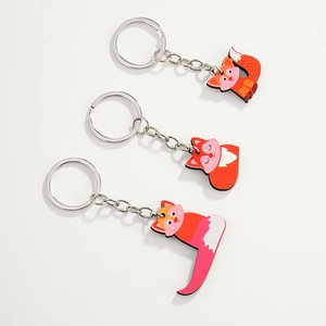 Detailed view of three cute red fox wooden keychains with durable silver metal rings