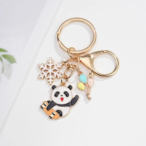 Detail of cute enamel panda keychain with colorful balloon and snowflake charms on gold ring
