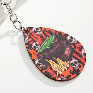 Detailed close-up of a teardrop-shaped Halloween wooden keychain with witch cauldron graphics
