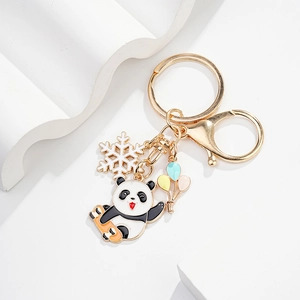 Detailed close-up of cartoon panda keychain with enamel charms on white display