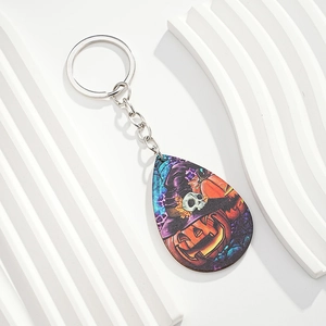 Detail of drop-shaped Halloween keychain featuring pumpkin, witch hat and skull graphics