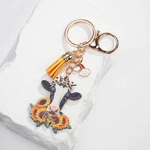 Detail of cow head and sunflower keychain with yellow tassel on stone texture