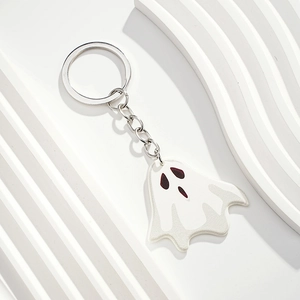 Close-up of a white ghost keychain for Halloween with a silver metal ring and chain