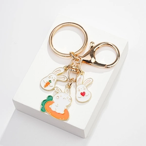 Detailed view of golden bunny keychain with enamel charms and lobster clasp attachment