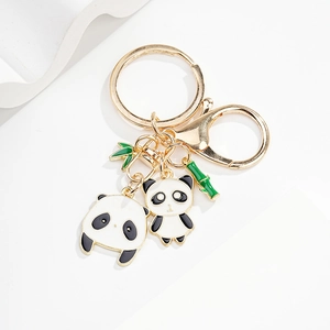 Detail of cute enamel panda keychain with gold plating and green bamboo charms