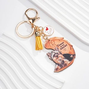 Detail of dog keychain with Yorkshire terrier charm, yellow tassel and golden lobster clasp