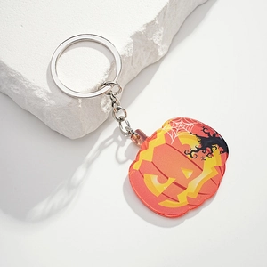Detail of orange acrylic pumpkin keychain with spider web and silver metal ring