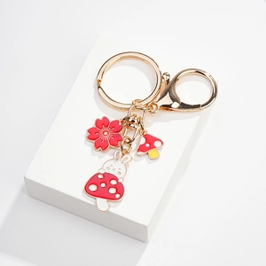 Cute white bunny on red mushroom keychain with gold ring and enamel flower charms