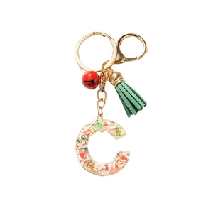 Christmas alphabet C resin keychain with mini snowman and green tassel on white background