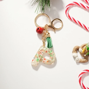 Détail du porte-clés lettre P en résine avec paillettes bonhomme de neige et grelot