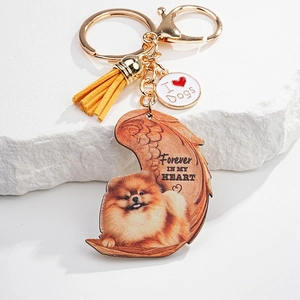 Detail of Pomeranian acrylic keychain with golden clasp, yellow tassel, and memorial text