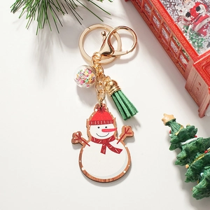 Detail view of a cute wooden snowman keychain with green tassel and star-filled clear ball
