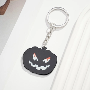 Detailed view of Halloween pumpkin ghost keychain with black enamel finish and silver chain