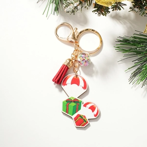 Détail d'un porte-clés de Noël avec pompon rouge, boule étoilée et pendentifs de cadeaux