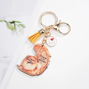 Detailed view of Pomeranian dog angel wing keychain with yellow leather tassel