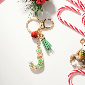 Macro detail of Christmas letter J keychain with green tassel and red bell charms